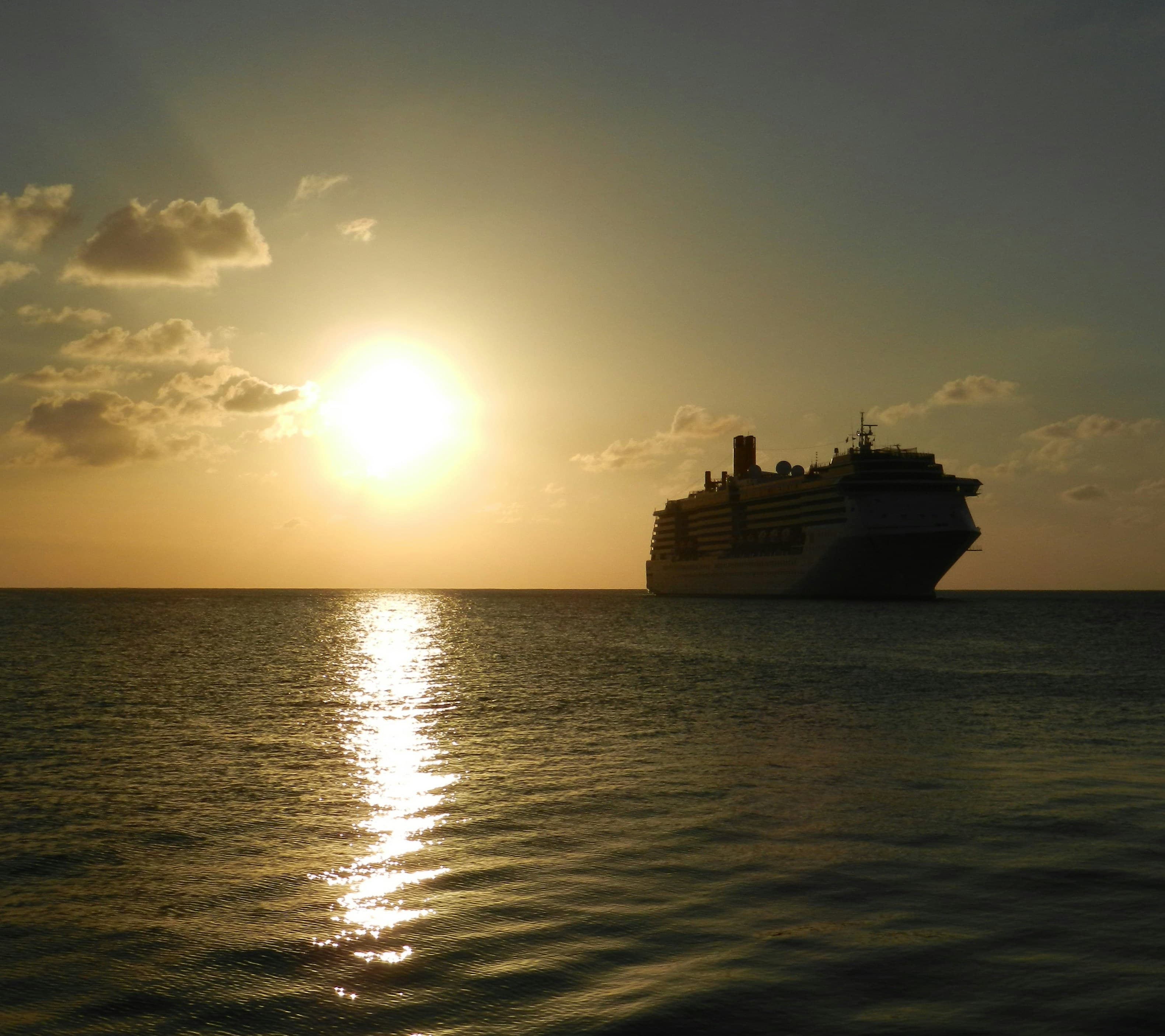 Luxury cruise ship sailing on calm ocean waters at sunset